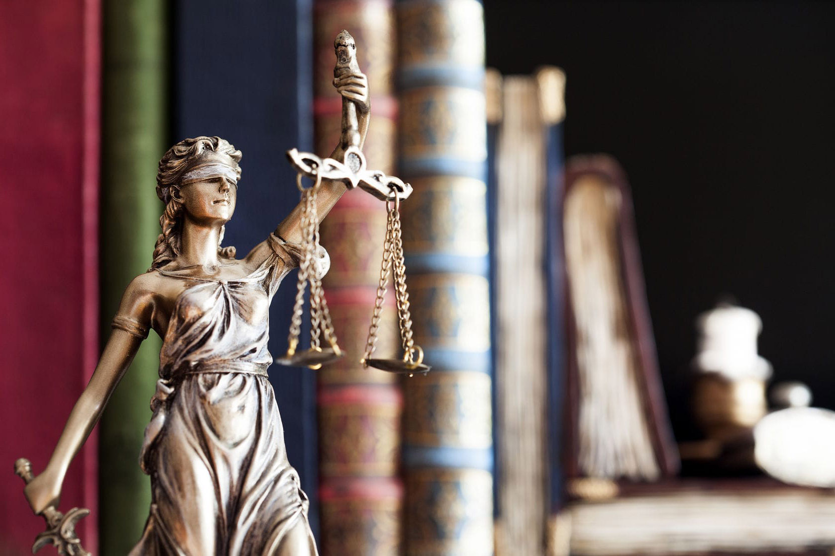 Photographic Image of blindfolded statue holding balanced scales representing justice